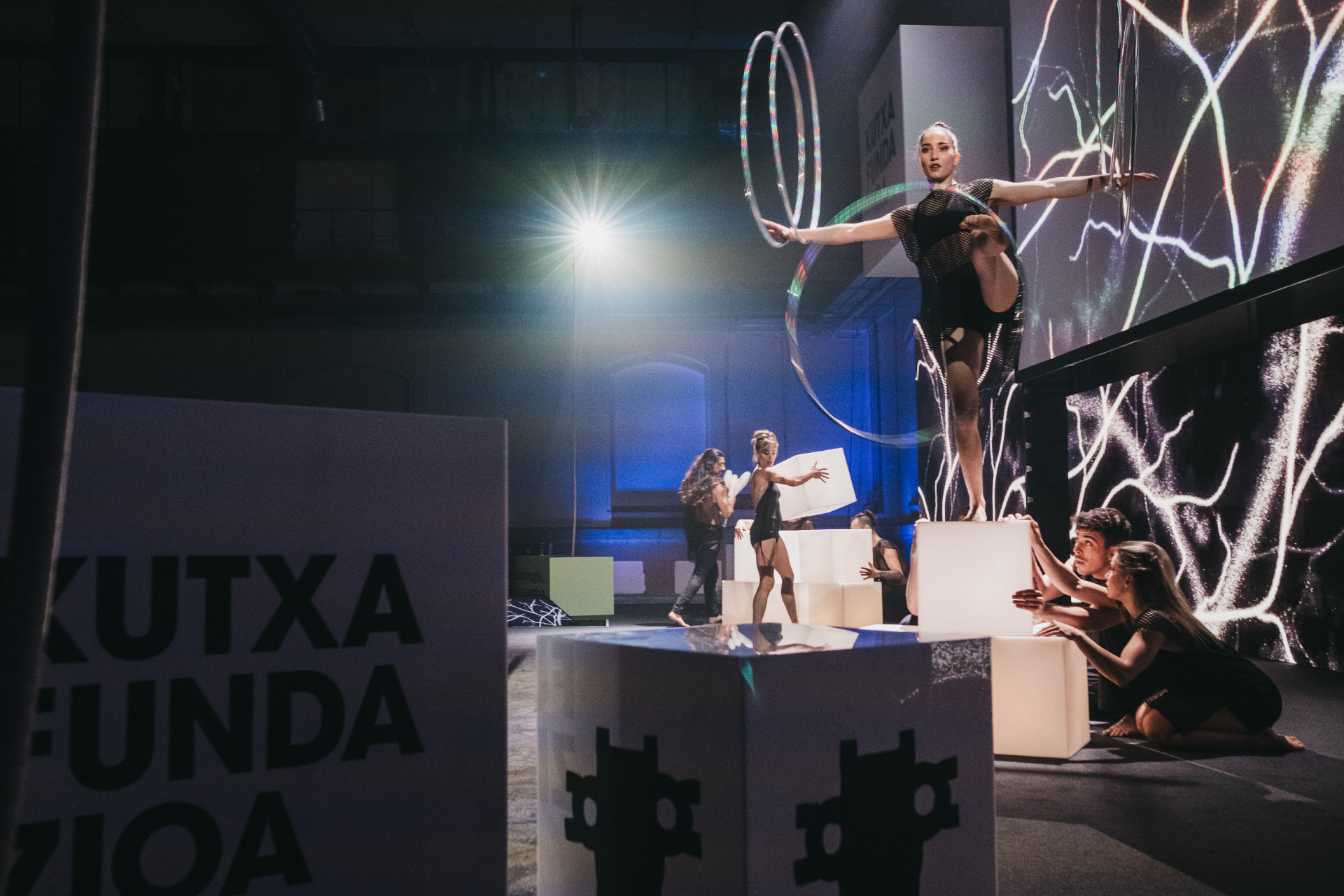 Artistas de ZirKuSS en una composición con cubos de luz